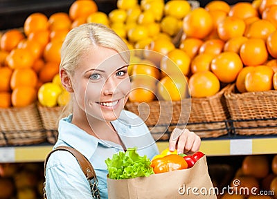 Girl keeps paper bag with fresh vegetables