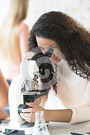 Girl Looking Through Microscope In Chemistry Class