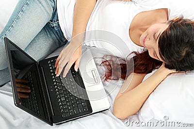 Girl lying in bed with laptop