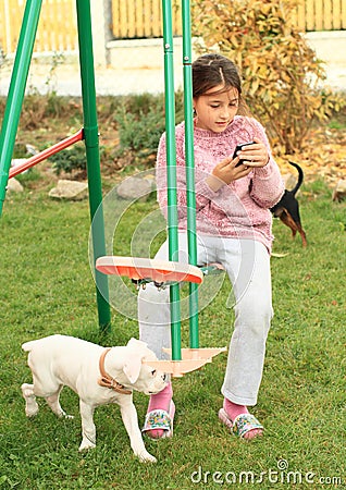 Girl with mobil phone on swing