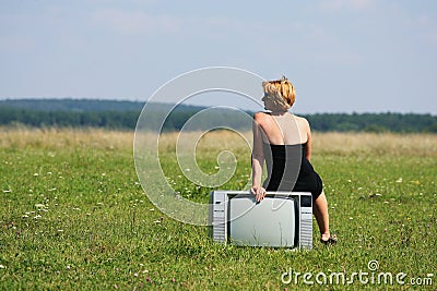 Girl with old tv at the middle of the fields