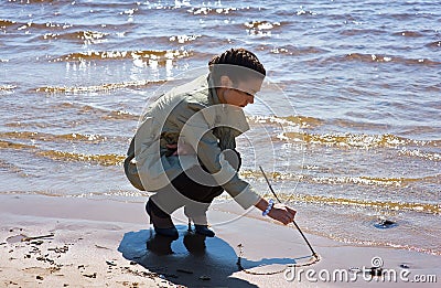 Girl painting a heart on the sand