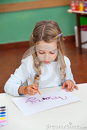 Girl Painting Name On Paper At Desk
