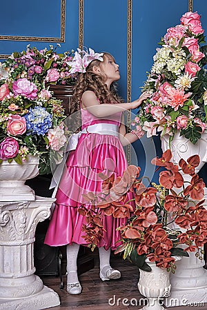 Girl in a pink dress among the flowers