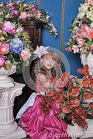 Girl in a pink dress among the flowers