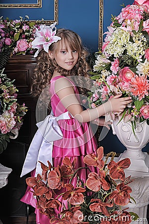 Girl in a pink dress among the flowers