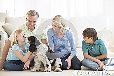 Girl Playing With Dog While Family Looking At Her