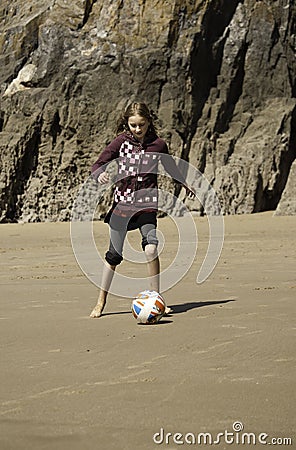 Girl Playing Football on the Beach