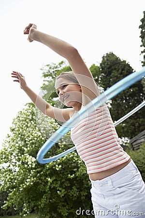 Girl Playing With Hula Hoop In Backyard