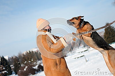 Girl playing with jumping dog against blue sky