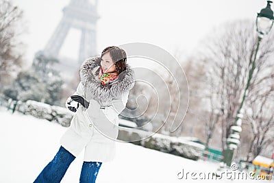 Girl playing snowball in Paris on a winter day