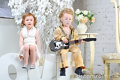 Girl and pop musician with guitar sit on letters