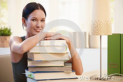 Girl posing with pile of books to learn