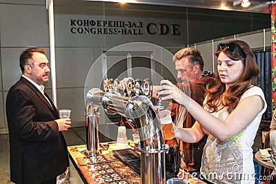 Girl pouring beer to glass from beer tap