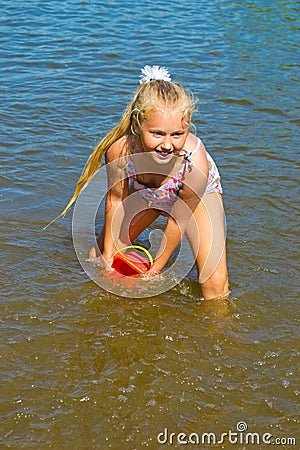 Girl pouring water from a bucket