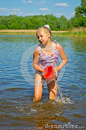 Girl pouring water from a bucket