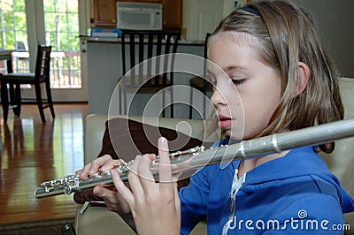 Girl practicing flute at home