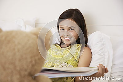 Girl Reading Story Book To Her Teddy Bear