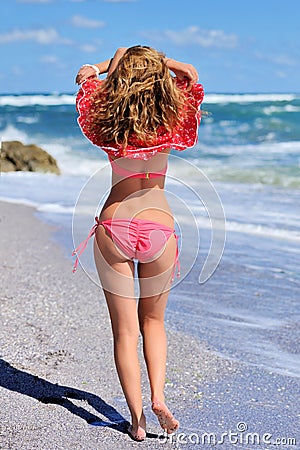 Girl in a red dress on the ocean coast