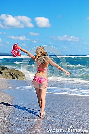 Girl in a red dress on the ocean coast