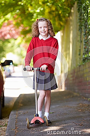 Girl Riding Scooter On Her Way To School