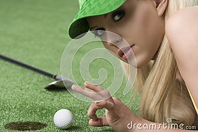 Girl s playing with golf ball looks in to the lens