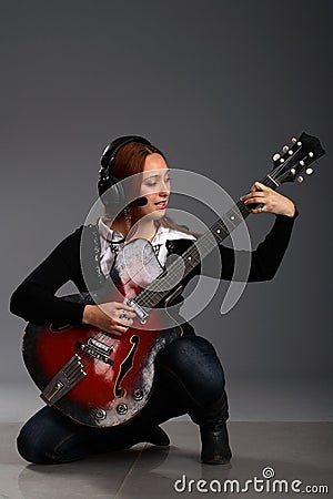 Girl sitting with bass guitar and play music