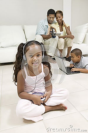 Girl sitting on living room floor Listening to Music on Portable CD Player portrait