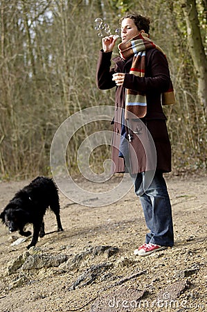 Girl, soap bubbles and wet black dog