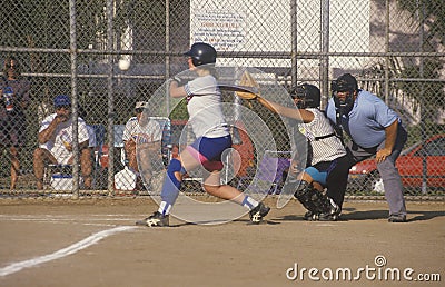 Girl swinging bat at Girls Softball game