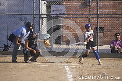 Girl swinging bat at Girls Softball game