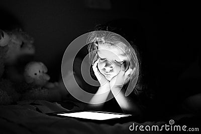 Girl with tablet in a dark