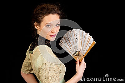 Girl in Victorian dress with fan in profile