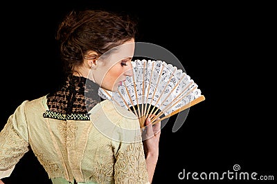 Girl in Victorian dress with fan seen from the back
