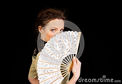 Girl in Victorian dress hinding behind a fan
