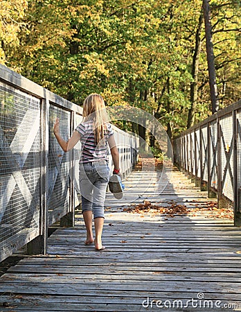 Girl walking on wooden bridge