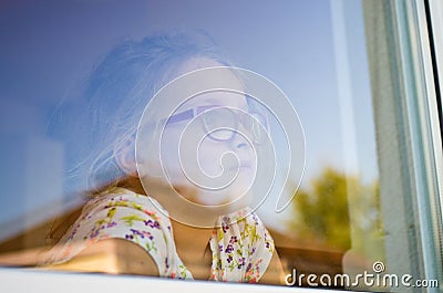 Girl in a window with garden refelctions