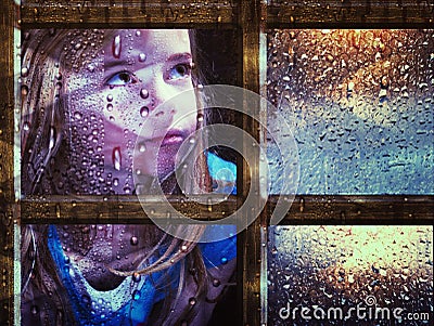 Girl at window in rain