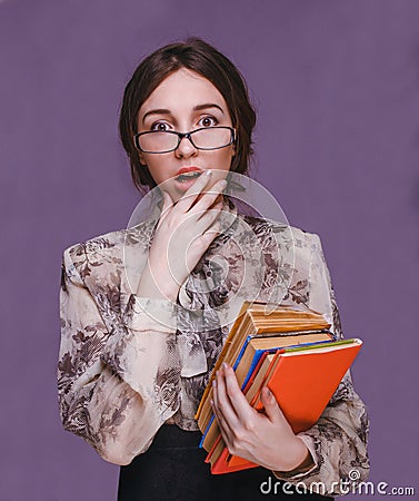 Girl woman brunette teacher in glasses with books surprised open