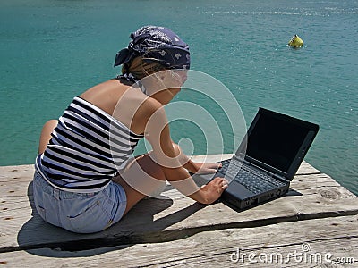 Girl with wrap and laptop on sea
