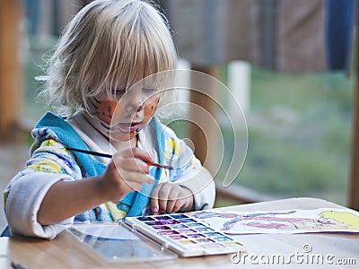 The girl of 3 years draws paints