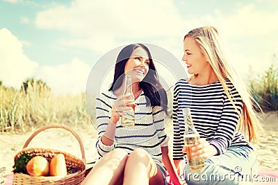 Girlfriends with bottles of beer on the beach