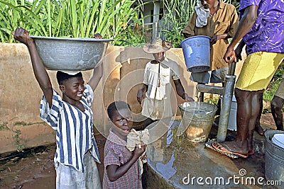 Girls fetch water at a water pump
