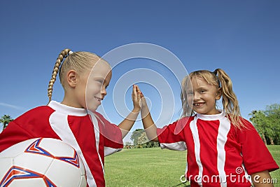 Girls Giving a High-Five On Soccer Field