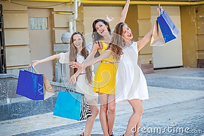 Girls having fun together. Girls holding shopping bags and walk