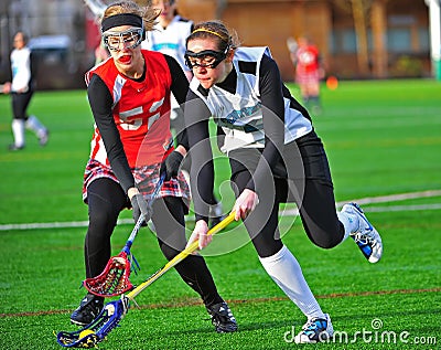 Girls Lacrosse scooping the ball