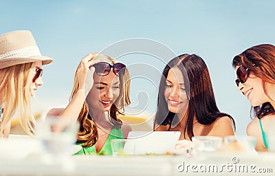 Girls looking at tablet pc in cafe
