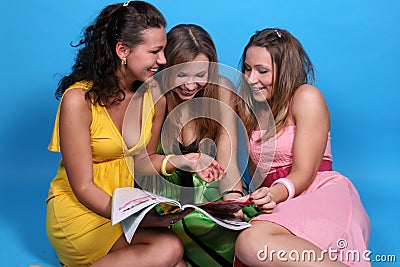 Girls read glossy magazine