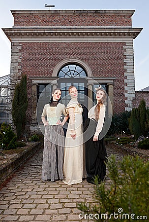 Girls in Victorian in front of old house