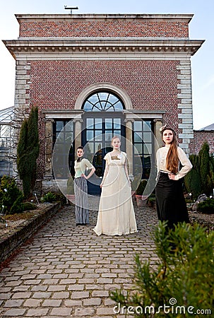 Girls in Victorian in front of old house